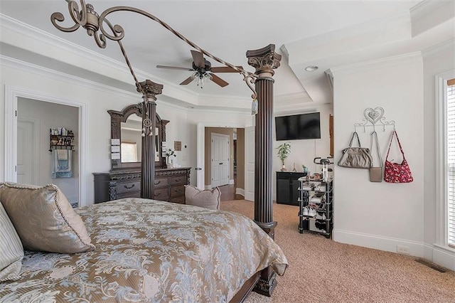 bedroom featuring visible vents, ornamental molding, a tray ceiling, carpet floors, and decorative columns