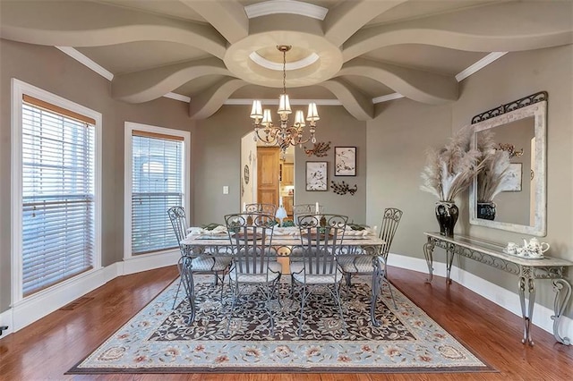 dining space featuring baseboards, a notable chandelier, wood finished floors, and crown molding