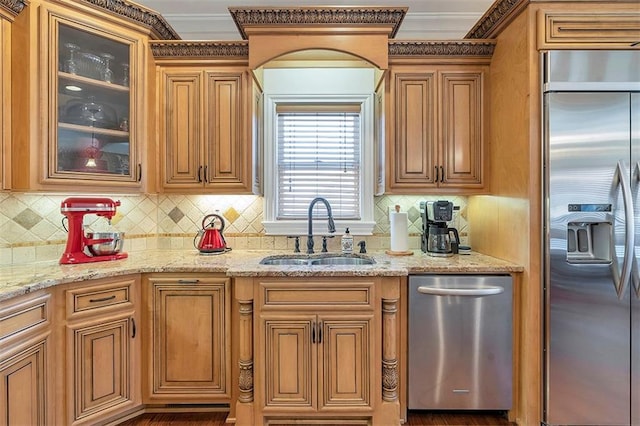 kitchen featuring light stone counters, appliances with stainless steel finishes, glass insert cabinets, and a sink