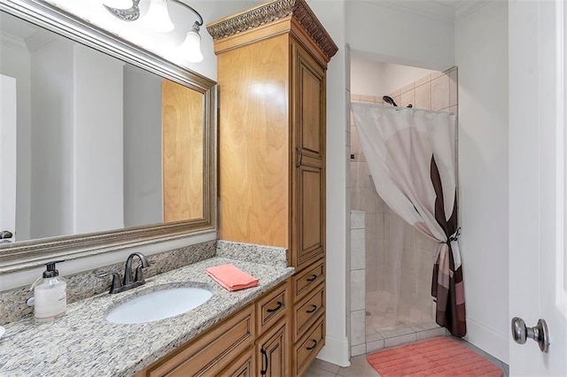 full bath featuring a tile shower, tile patterned flooring, vanity, and ornamental molding