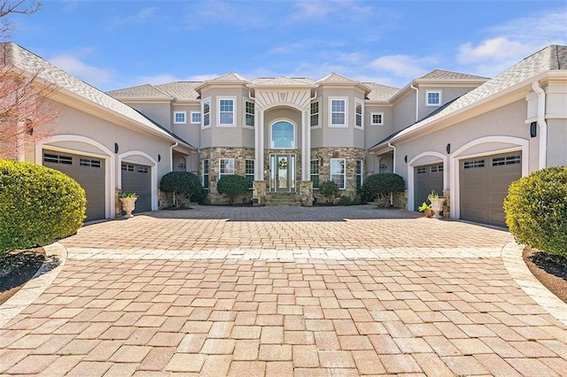 mediterranean / spanish home with decorative driveway, a garage, and stucco siding