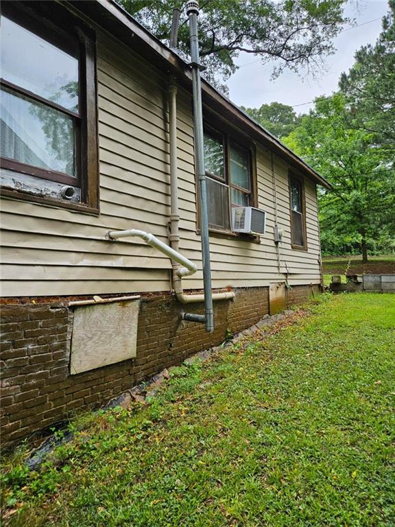 view of home's exterior featuring cooling unit and a lawn