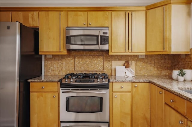 kitchen with appliances with stainless steel finishes, light stone countertops, and decorative backsplash