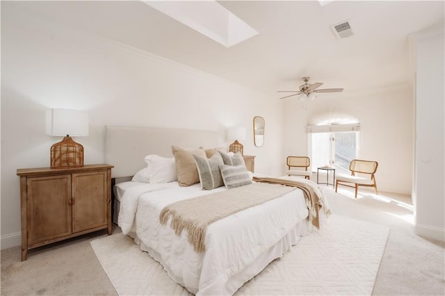 bedroom featuring light carpet, a skylight, and ceiling fan