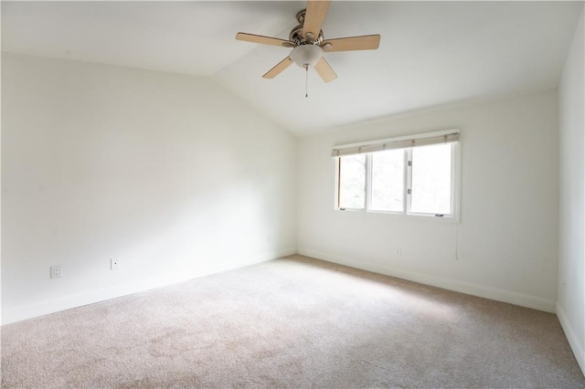 carpeted spare room featuring ceiling fan and vaulted ceiling