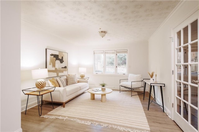 living area featuring hardwood / wood-style floors, ornamental molding, and a textured ceiling