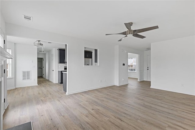 unfurnished living room featuring ceiling fan and light hardwood / wood-style floors