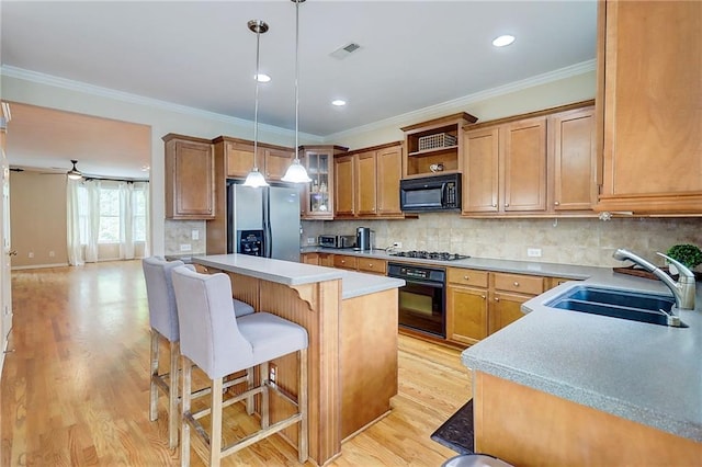 1160 Newpark View Pl Unit 8, Mableton, GA 30126 - kitchen with black appliances, a breakfast bar area, a kitchen island, brown cabinets, and light countertops