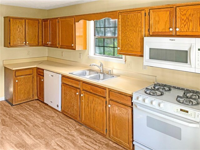 kitchen with sink, light wood-type flooring, and white appliances