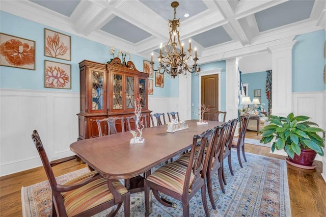 dining room featuring coffered ceiling, crown molding, hardwood / wood-style flooring, beamed ceiling, and decorative columns