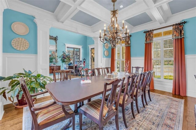 dining area featuring beamed ceiling, light hardwood / wood-style floors, ornamental molding, and coffered ceiling