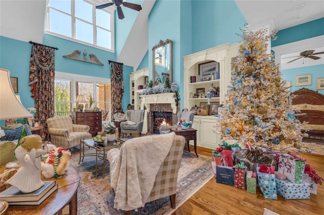 living room featuring a high ceiling, light hardwood / wood-style floors, and ceiling fan