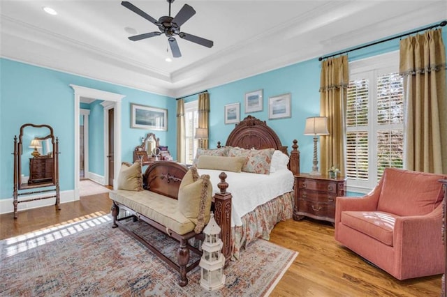 bedroom with wood finished floors, baseboards, multiple windows, and ornamental molding