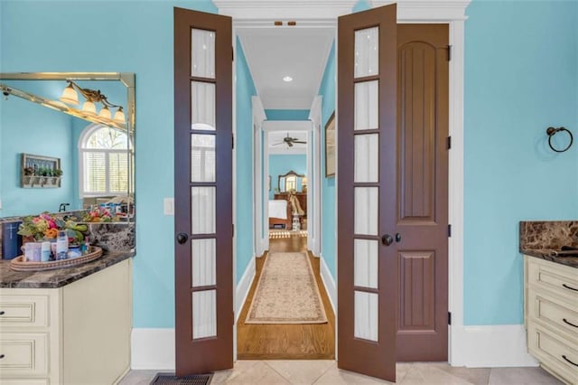 hallway featuring light tile patterned flooring and french doors