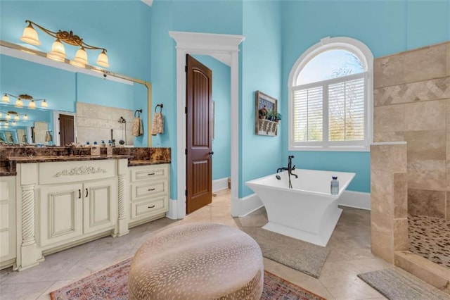 bathroom with tile patterned flooring, a soaking tub, vanity, and walk in shower