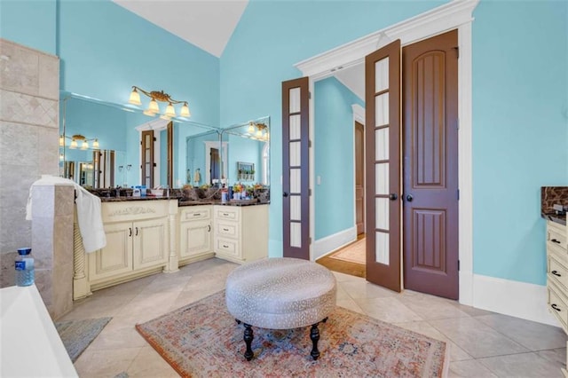 bathroom featuring tile patterned flooring, french doors, vanity, and vaulted ceiling