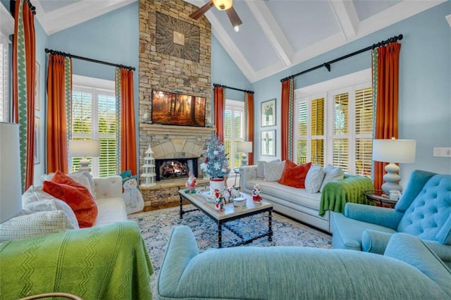 living room featuring beam ceiling, ceiling fan, a fireplace, and high vaulted ceiling