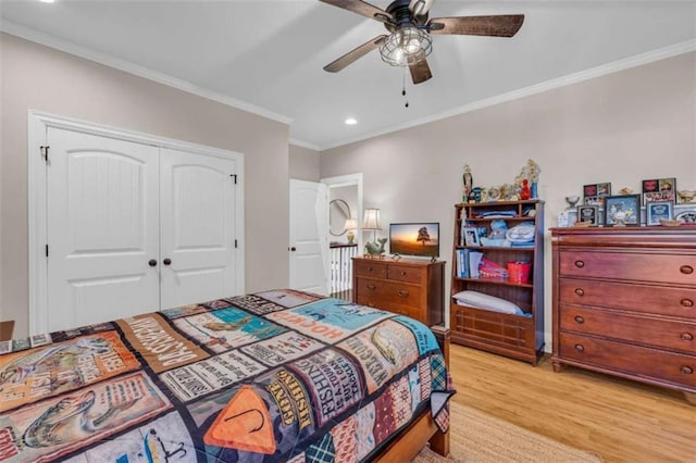 bedroom featuring ceiling fan, a closet, crown molding, and light hardwood / wood-style floors