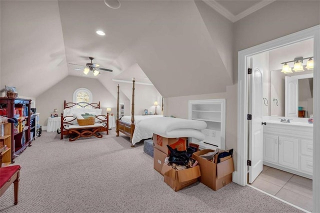 bedroom featuring ensuite bath, ceiling fan, light carpet, and vaulted ceiling