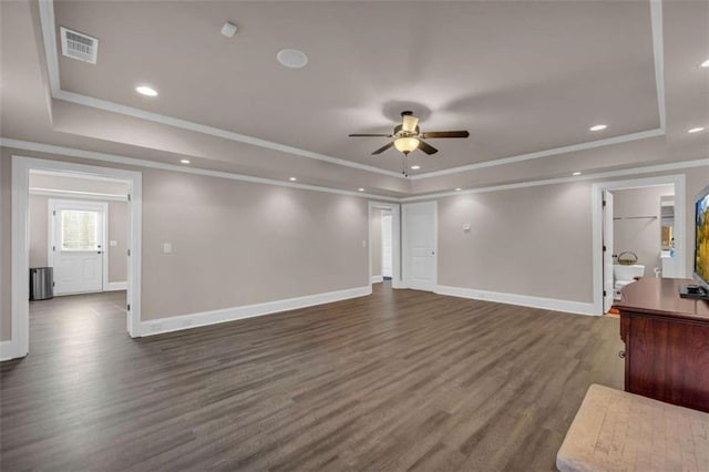 unfurnished living room featuring ceiling fan, a raised ceiling, and dark wood-type flooring