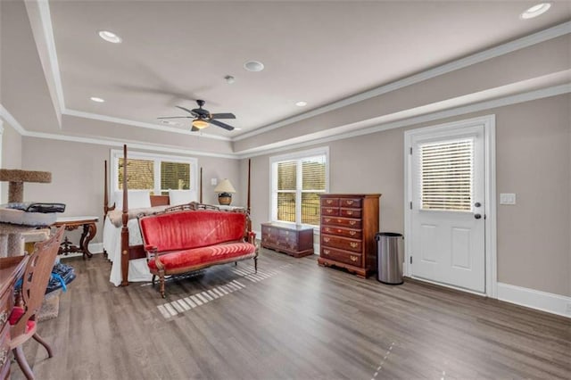 bedroom featuring multiple windows, wood-type flooring, ceiling fan, and ornamental molding