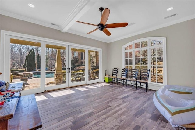 sunroom / solarium featuring french doors, ceiling fan, a healthy amount of sunlight, and beam ceiling