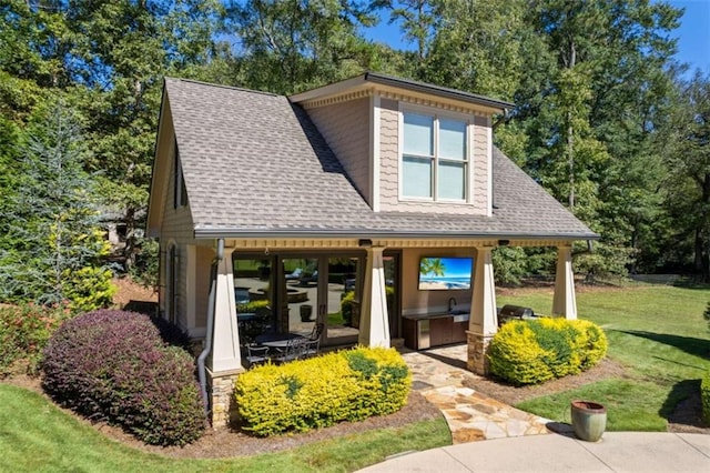 exterior space with a front lawn and roof with shingles