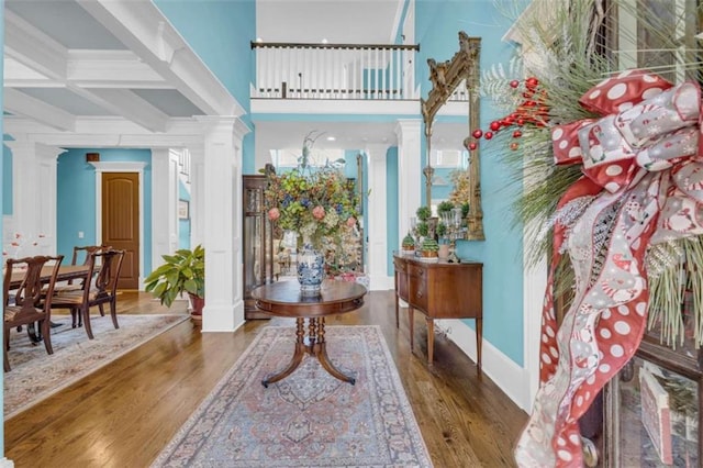 entrance foyer with decorative columns, beamed ceiling, dark wood-type flooring, and coffered ceiling