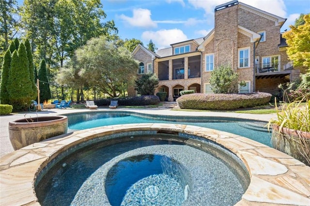 view of swimming pool featuring an in ground hot tub