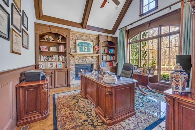 home office with plenty of natural light, ceiling fan, light wood-type flooring, and a fireplace