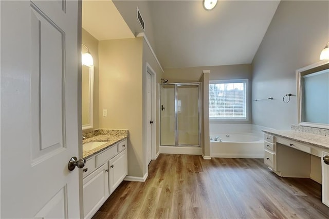 bathroom featuring lofted ceiling, plus walk in shower, hardwood / wood-style floors, and vanity