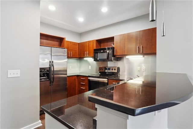 kitchen with appliances with stainless steel finishes, a breakfast bar, and kitchen peninsula