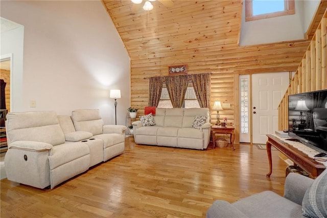 living room with wood ceiling, high vaulted ceiling, log walls, and light hardwood / wood-style floors