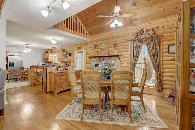 dining space with track lighting, high vaulted ceiling, ceiling fan, and light wood-type flooring