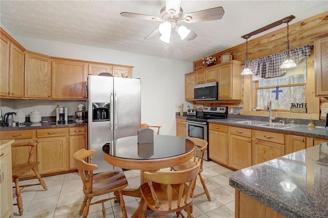 kitchen with sink, hanging light fixtures, light tile patterned floors, appliances with stainless steel finishes, and ceiling fan