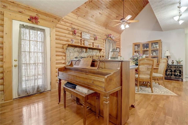 miscellaneous room featuring log walls, light hardwood / wood-style floors, and a textured ceiling