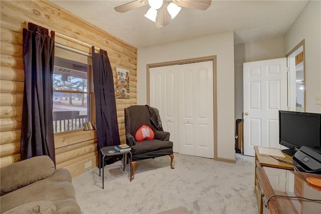 sitting room with light carpet, rustic walls, and ceiling fan