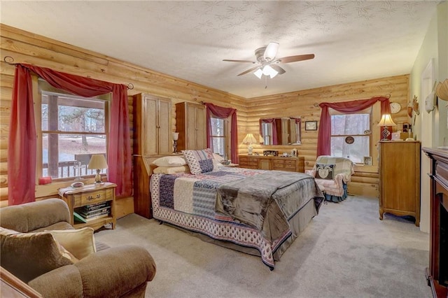 carpeted bedroom featuring ceiling fan, a fireplace, and a textured ceiling