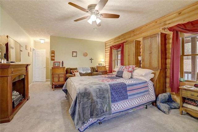 bedroom with multiple windows, light carpet, and a textured ceiling