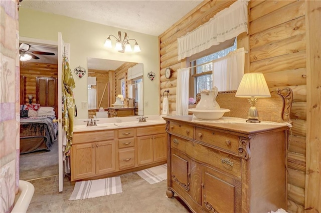 bathroom with vanity, ceiling fan, a textured ceiling, and rustic walls