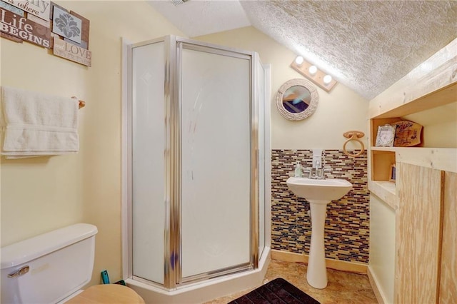 bathroom featuring lofted ceiling, a shower with door, tile walls, a textured ceiling, and toilet