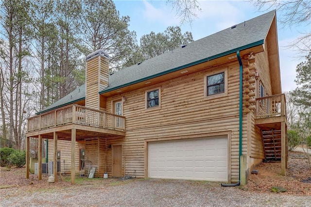 rear view of property featuring a garage and a deck