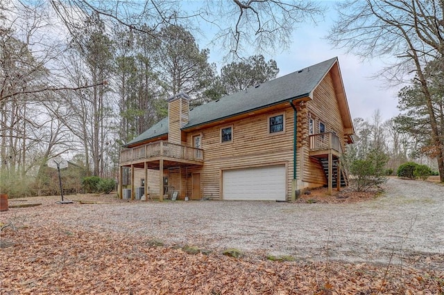 back of house featuring a garage, a deck, and central air condition unit