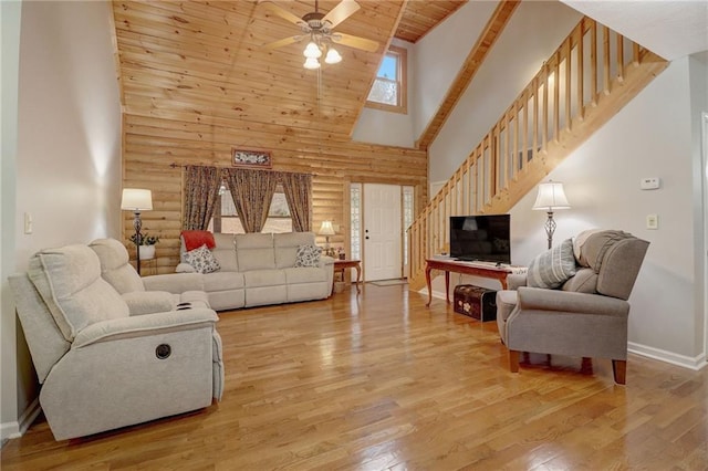 living room with wood ceiling, light hardwood / wood-style flooring, ceiling fan, high vaulted ceiling, and log walls