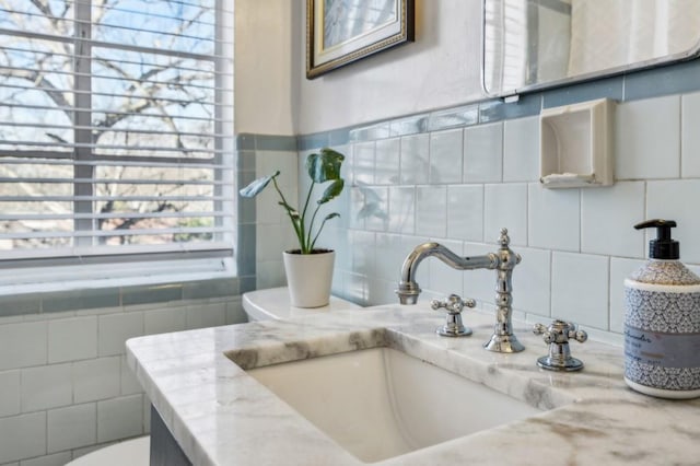 bathroom featuring toilet, vanity, and tile walls