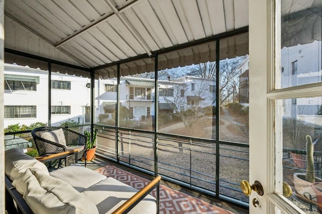 sunroom / solarium featuring lofted ceiling and plenty of natural light