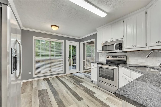 5407 Palmetto Ct, Flowery Branch, GA 30542 - kitchen featuring appliances with stainless steel finishes, a sink, a textured ceiling, white cabinetry, and backsplash