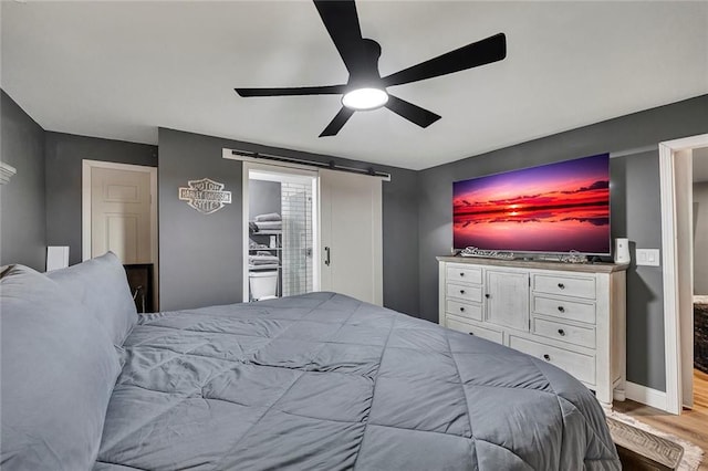 5407 Palmetto Ct, Flowery Branch, GA 30542 - bedroom featuring wood finished floors, a barn door, a ceiling fan, and baseboards