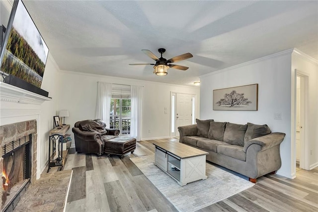 5407 Palmetto Ct, Flowery Branch, GA 30542 - living area with a lit fireplace, crown molding, ceiling fan, light wood-style flooring, and baseboards