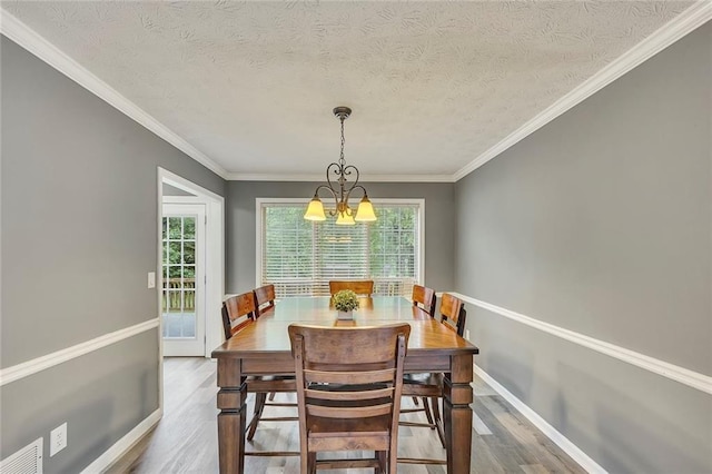5407 Palmetto Ct, Flowery Branch, GA 30542 - dining area with wood finished floors, a chandelier, ornamental molding, baseboards, and a textured ceiling